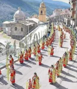 a group of people in orange robes walking down a street at appartamento in casa Lai in Desulo
