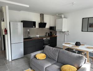 a living room with a couch and a kitchen at Appartement avec terrasse au Puy in Le Puy en Velay