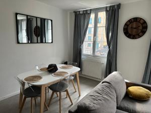- un salon avec une table et un canapé dans l'établissement Appartement avec terrasse au Puy, au Puy-en-Velay