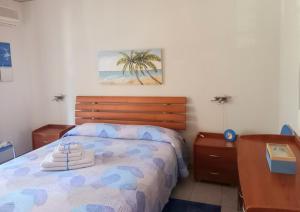Schlafzimmer mit einem Bett mit einem Kopfteil aus Holz in der Unterkunft Blu Corallo in Mascali
