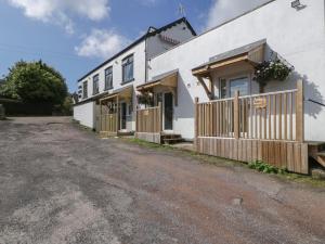 a white house with a fence and a driveway at Deers Leap in Lydney