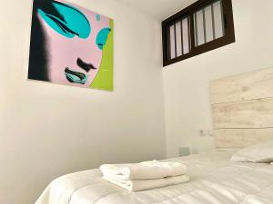 1 dormitorio con 1 cama con una foto en la pared en Sunhome apartment, en Mogán