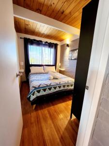 a bedroom with a bed in a room with wooden floors at Villa 29 Beach Spa Pool in Mandurah