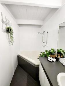 a bathroom with a bath tub and a sink and a bath tub at Villa 29 Beach Spa Pool in Mandurah