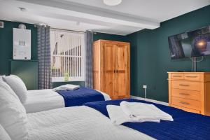 Duas camas num quarto com paredes azuis em Crawford Square Apartment em Derry Londonderry