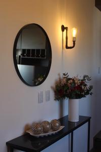 una mesa con espejo y un jarrón de flores en Luminoso y acogedor apartamento en San Juan
