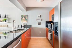 a kitchen with a sink and a stainless steel refrigerator at Brickell Center w/City & Bay View + FREE Parking! in Miami