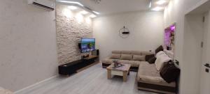 a living room with a couch and a tv at Villa Vishnyovka in Baku
