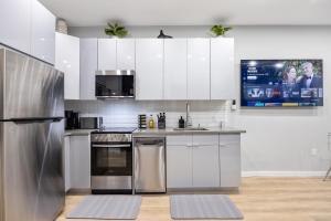 a kitchen with white cabinets and stainless steel appliances at SWJ G - Save on 2Day or more Stays 25min to Times Sq in New York