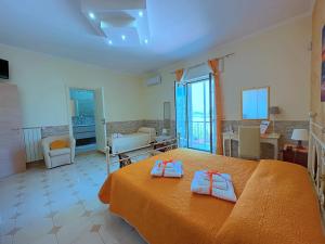 ein Schlafzimmer mit einem Bett mit zwei Handtüchern darauf in der Unterkunft B&B Afrodite in Leporano
