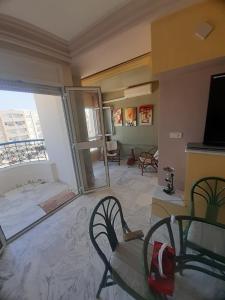 a living room with a table and chairs and a large window at Afnane 3 in Chott Meriem