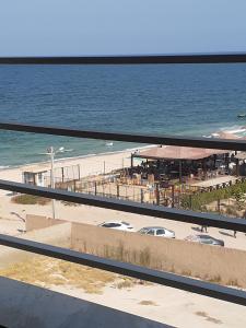 a view of a beach and the ocean from a balcony at Afnane 3 in Chott Meriem