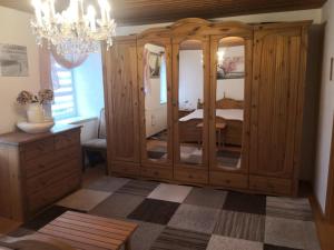 a bedroom with a chandelier and a wooden cabinet at Landhaus-Ferien-Sommer in Bleckede