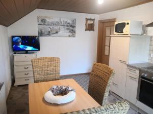 eine Küche mit einem Tisch und Stühlen sowie einem TV in der Unterkunft Landhaus-Ferien-Sommer in Bleckede