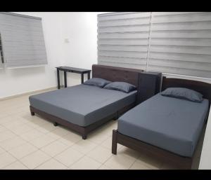 two beds sitting next to each other in a room at Amilite Villa in Gelugor