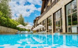 a swimming pool with chairs and umbrellas next to a building at Apartament by Zenit in Terra Complex C30 in Razlog