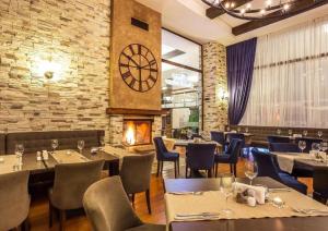 a restaurant with tables and chairs and a clock on the wall at Apartament by Zenit in Terra Complex C30 in Razlog