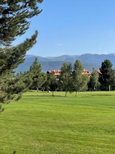 a green field with trees and buildings in the background at Apartament by Zenit in Terra Complex C30 in Razlog