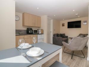 a kitchen and living room with a table with two wine glasses at Badgers Sett in Lydney