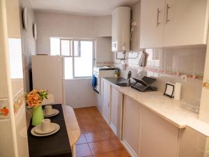 a kitchen with white cabinets and a counter top at Casa D'Olívia in Carrapateira