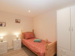 a small bedroom with a bed and a cabinet at Badgers Sett in Lydney