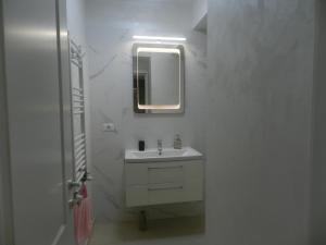 a white bathroom with a sink and a mirror at Mamaia Nord-Astoria Lake-Studio in Mamaia