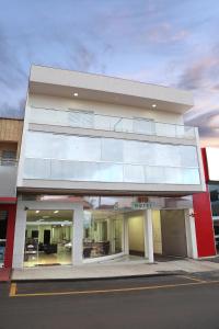 a white building with glass windows on a street at Big Hotel in Araguari