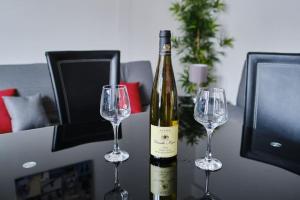 a bottle of wine and two wine glasses on a table at Central flat in Basingstoke in Basingstoke