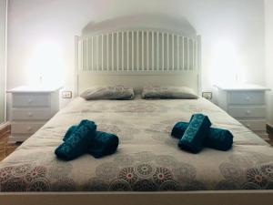um quarto com uma cama grande e duas almofadas azuis em Live Arico Lapa cerca de la playa em Arico