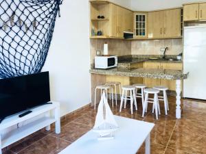uma cozinha com um balcão com bancos e um balcão em Live Arico Lapa cerca de la playa em Arico
