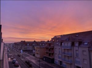 a view of a city street with a sunset at Appartement Stella-Plage in Cucq +3 photos