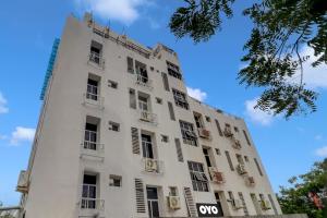 un grand bâtiment blanc avec des fenêtres et un ciel bleu dans l'établissement Qualia Heights Madhapur Beside Cyber Tower, à Hyderabad