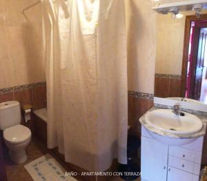 y baño con lavabo, aseo y cortina de ducha. en Casa Valle, en Cangas de Onís