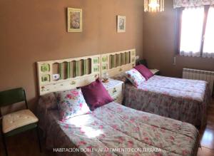 a bedroom with two beds and a chair at Casa Valle in Cangas de Onís