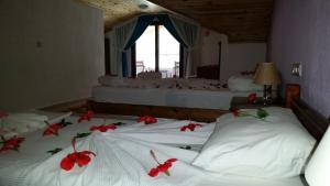 - une chambre avec 2 lits avec des fleurs rouges dans l'établissement Hotel Riverside, à Dalyan