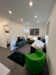 a living room with a green chair and a bed at Modern flat in central Egham by Windsor Castle, Staines-Upon-Thames and Heathrow Airport in Egham