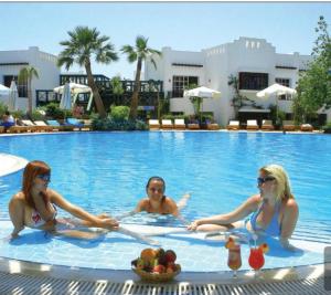 Trois femmes sont assises à la piscine dans l'établissement Delta sharm resort. Studio. Sharm el sheikh, à Charm el-Cheikh