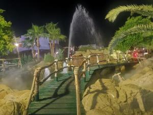 a bridge with a waterfall in a park at night at Delta sharm resort. Studio. Sharm el sheikh in Sharm El Sheikh