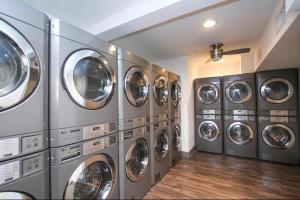 a bunch of washing machines in a laundry room at The Cozy Clouds Resort at NRG in Houston