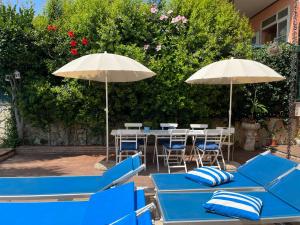 een groep blauwe tafels en parasols met stoelen bij B&B Euthalia in Riposto