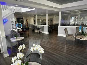 een lobby met tafels en stoelen en een restaurant bij The Hotel Redland in Homestead