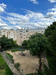 une aire de jeux dans un parc en face d'un bâtiment dans l'établissement Bel appartement cozy villejuif, à Villejuif