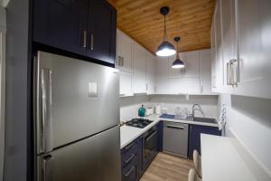 a kitchen with white cabinets and a stainless steel refrigerator at Archontiko Adamou in Kyperounda