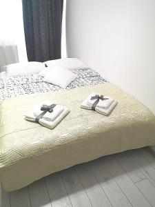 Una cama con toallas encima. en Modern Central Apartament, en Câmpulung Moldovenesc