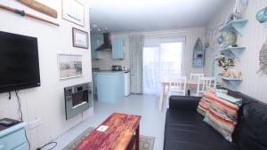 a living room with a couch and a table at 17H Medmerry Park 2 Bedroom Chalet in Earnley