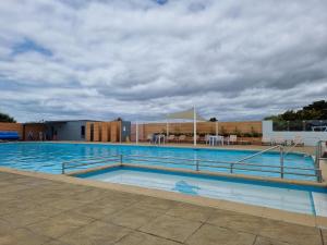 a large swimming pool on a cloudy day at 17H Medmerry Park 2 Bedroom Chalet in Earnley