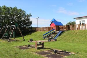 un parco giochi con scivolo e altalena di Grímsstaðir holiday home - Family friendly a Reykholt