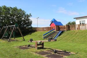 un parque infantil con tobogán y columpio en Grímsstaðir holiday home - Family friendly, en Reykholt