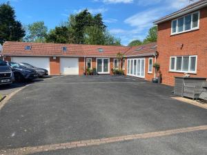 a brick house with a parking lot in front of it at Happy days 2 miles from Hoylake Wirral in Moreton