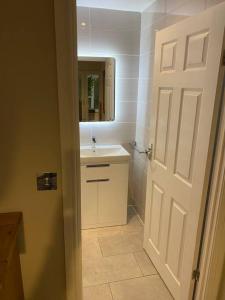 a bathroom with a white sink and a mirror at Happy days 2 miles from Hoylake Wirral in Moreton